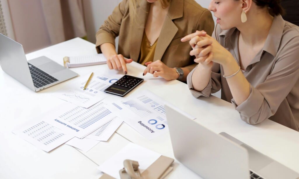 a woman pointing at a calculator