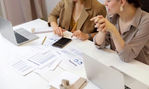 a woman pointing at a calculator